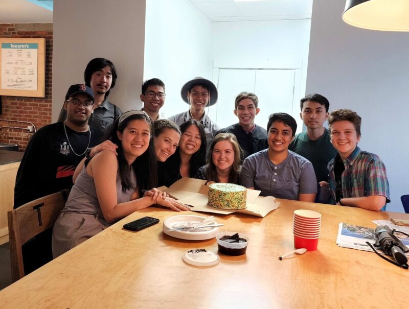 people gathered around an ice cream cake