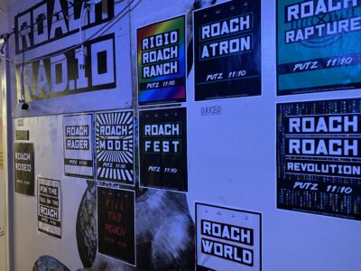 posters for a previous putz party that say "roach radio, roach fest, roach a tron, roach mode, roach rager"