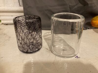 Two cups. The one on the right is large and clear; the one on the left is medium with a purple pattern that looks like a net.