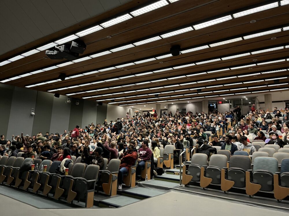 a full lecture hall of students and faculty getting ready to watch the movie