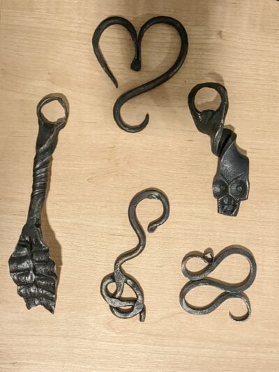 5 bottle openers: one skull, one leaf, one knot, a heart, and a wavy design
