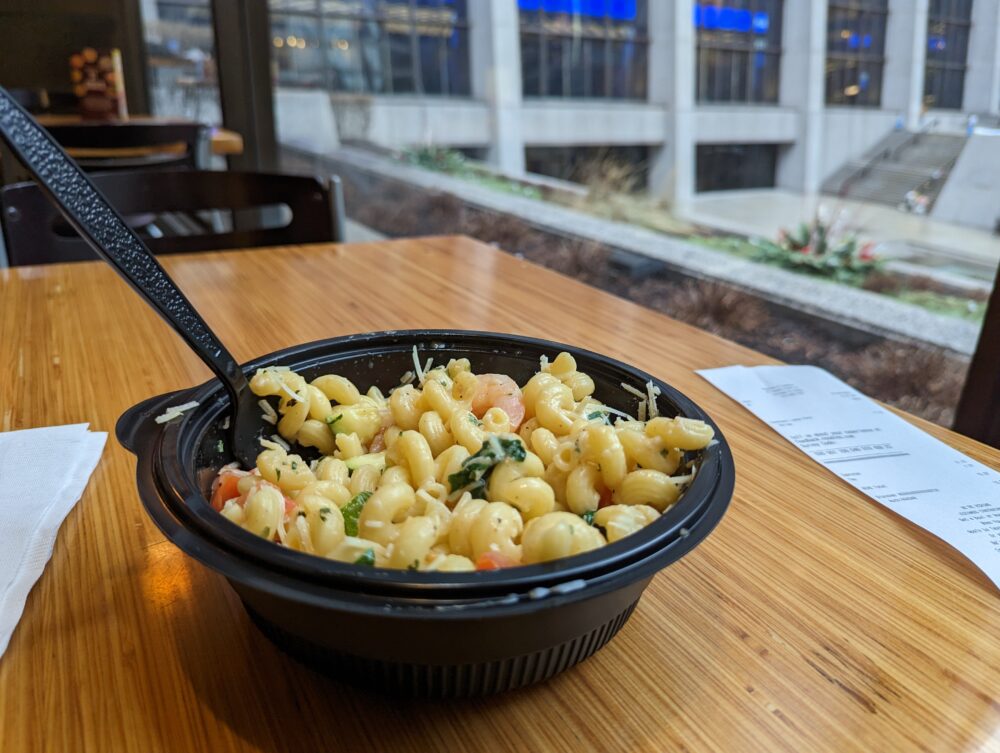 pasta on table with city plaza out-of-focus behind a window
