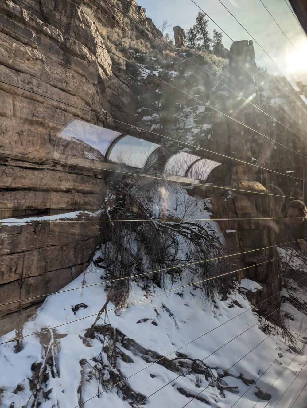 picture of a rocky cliff with snow, with lines in front of it