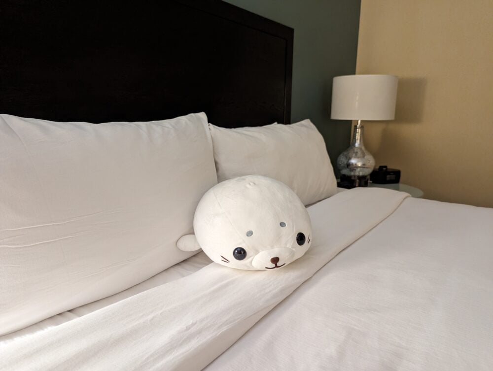 seal plush sitting on a hotel bed