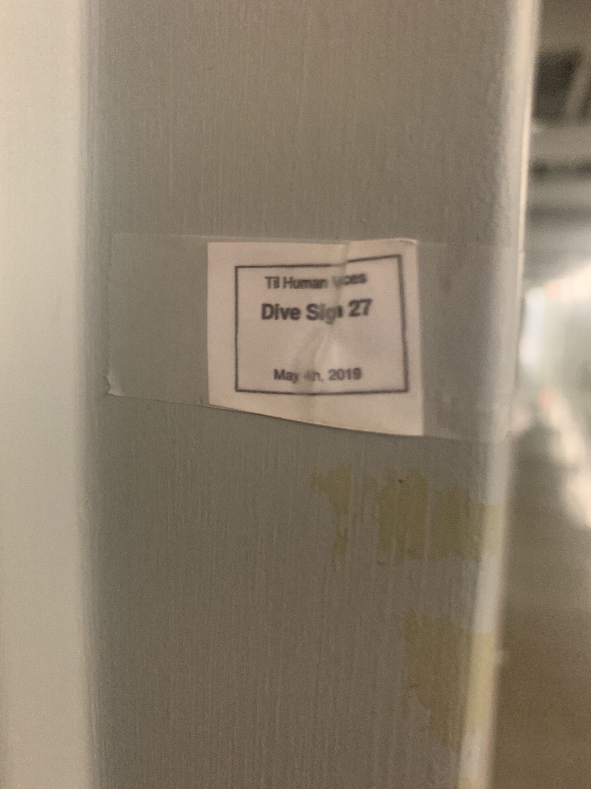 a small sign saying "Til Human Voices / Dive Sign 27 / May 4th, 2019"