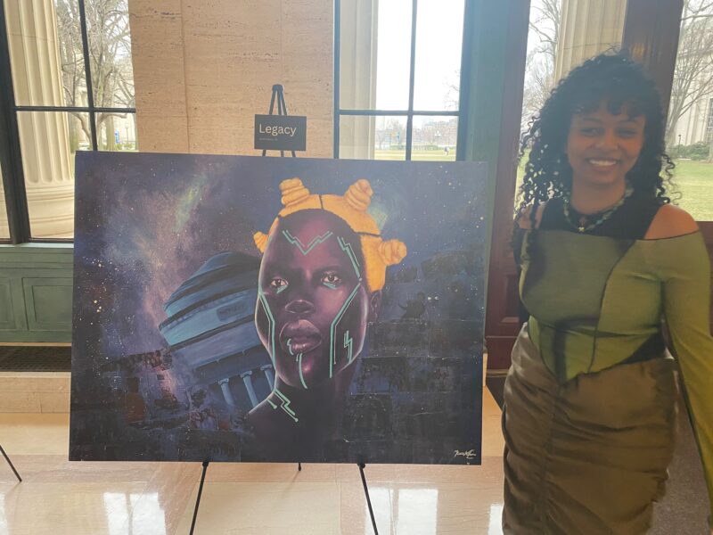 black woman next to a painting