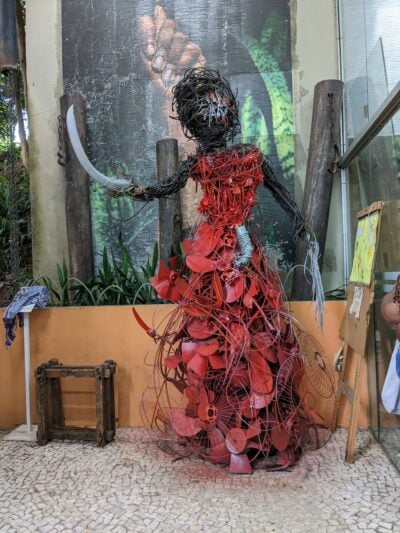sculpture of recycled materials of a woman in a red dress