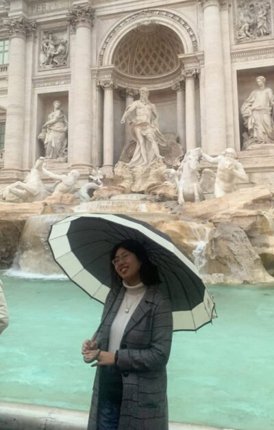 woman standing in front of the trevi fountain