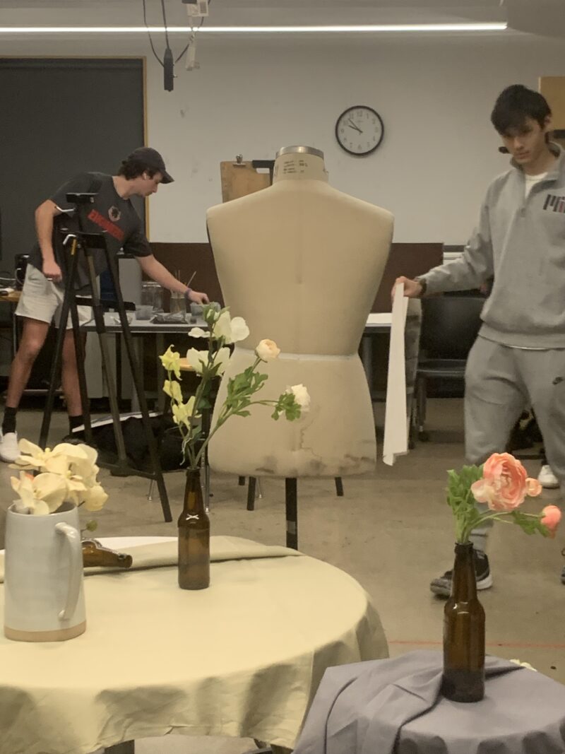 bottle of flowers next to a mannequin