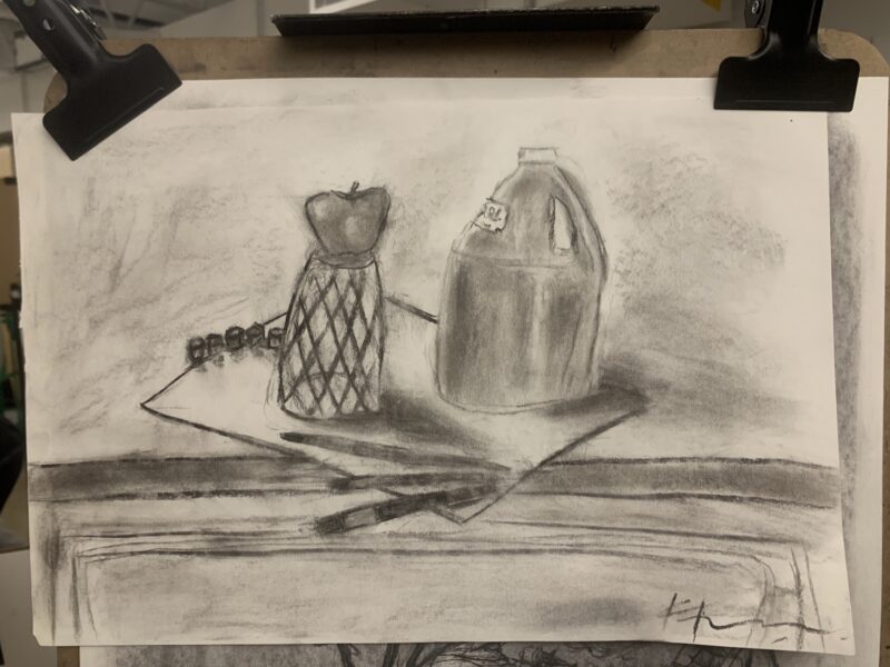drawing of an apple on a cup on a canvas, next to a paint bottle and brushes
