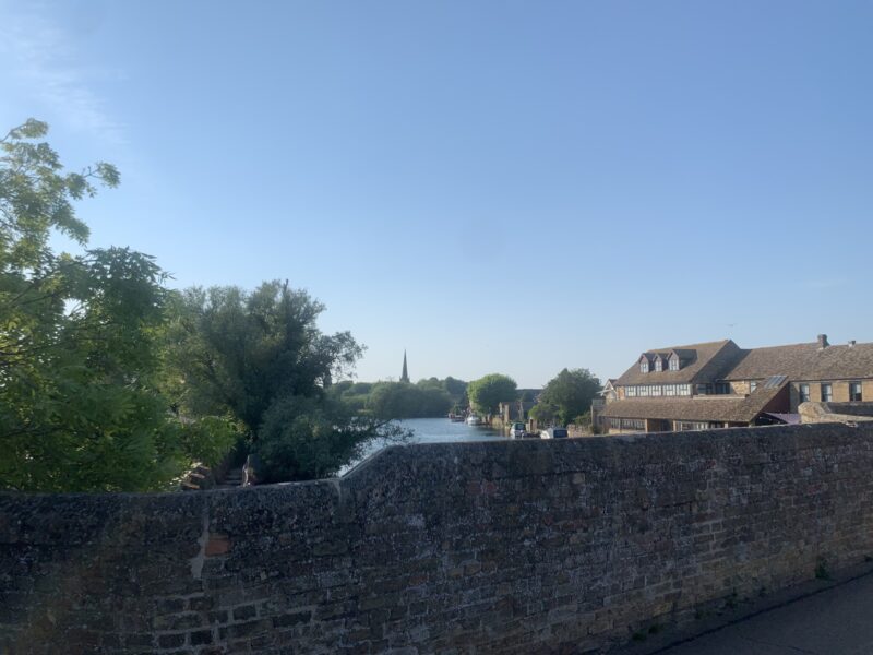 view from standing in the middle of a stone bridge overlooking a river