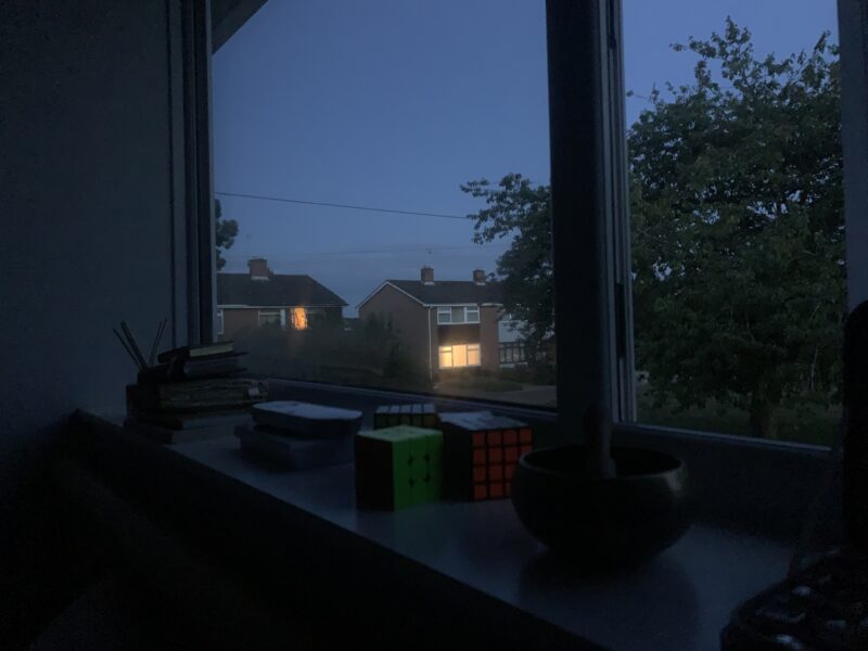 the neighbor's house at night, with an illuminated window
