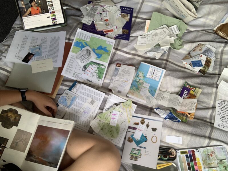 a bunch of scattered scrapbooking materials (receipts, photos, postcards, etc.)