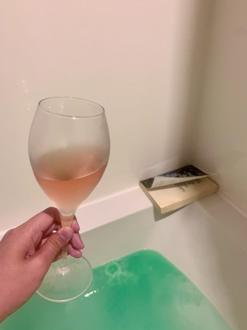 a glass of rose, a book, and a bath