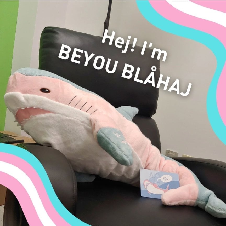 a shark plush with blue pink and white stripes