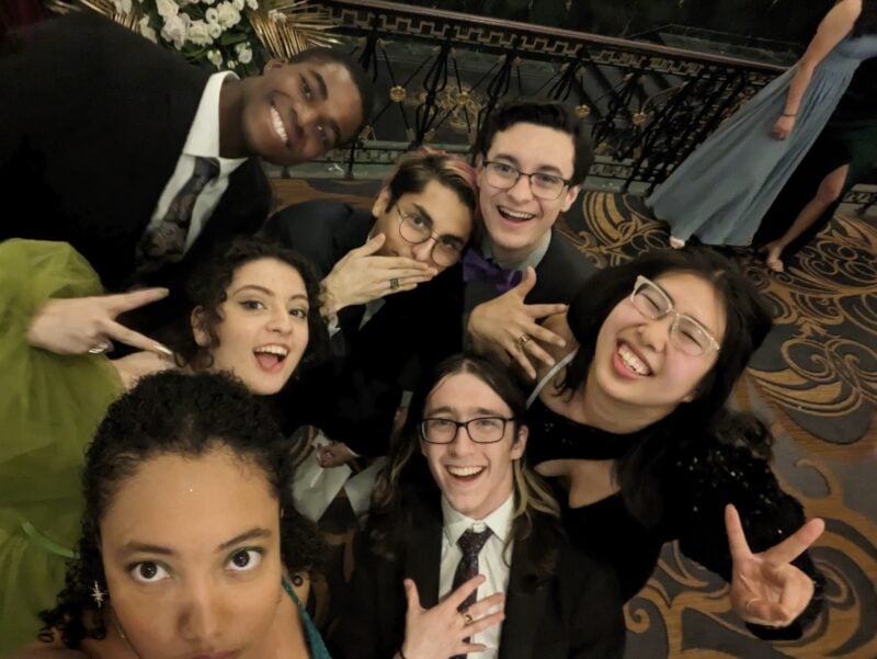 group of 7 friends posing taking a selfie together