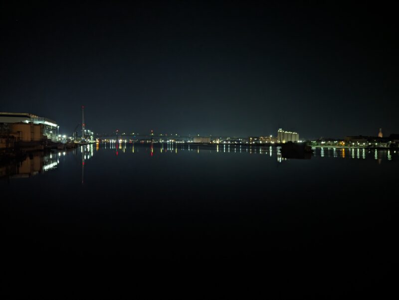 river at night with city lights reflected in the distance
