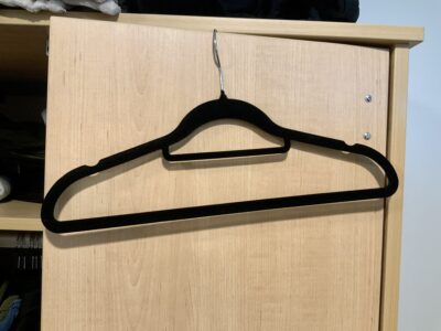 Black felt clothes hanger hanging on dresser door