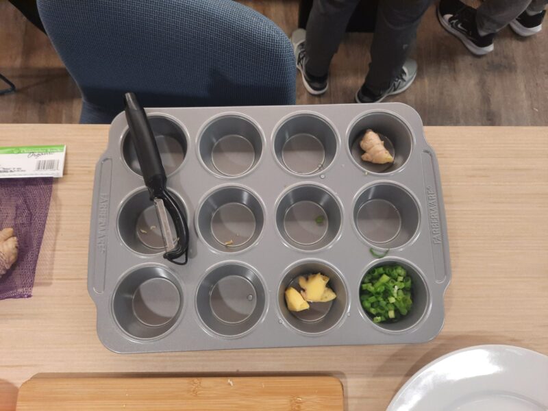 muffin tin with green onions & ginger being stored