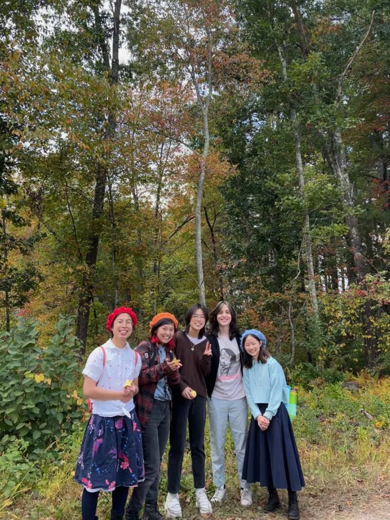 five kids posing in front of colorful trees