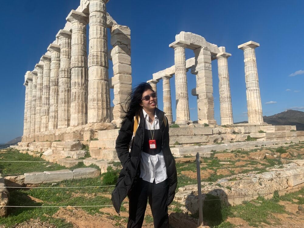 woman in front of a greek temple