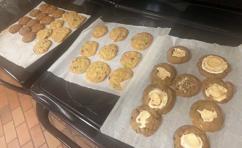 Image of cookie sheets with ginger oatmeal, m&m, and s'mores cookies