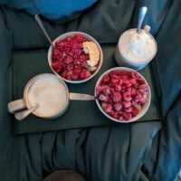 two bowls of raspberries and two cups of coffee