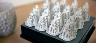 a picture of complicated, swirling clay forms 3D printed onto a print bed