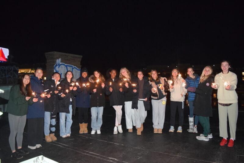 Team posing with sparklers.