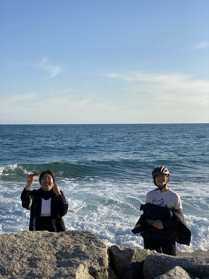 two women standing on the beach smiling