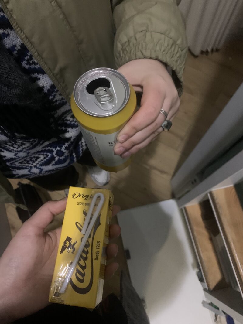 one person holding a can of beer and another person holding chocolate milk