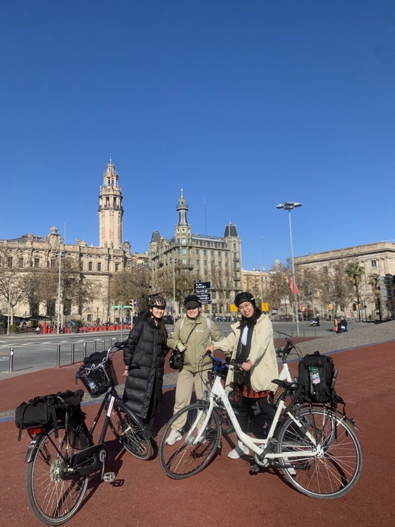 three people standing with their bikes