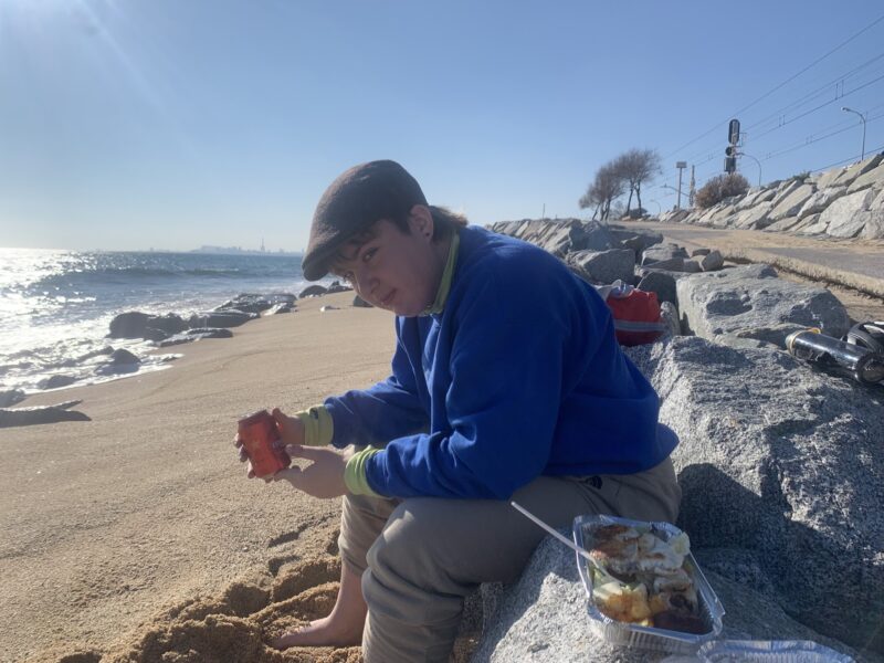 person holding a beer can at the beach