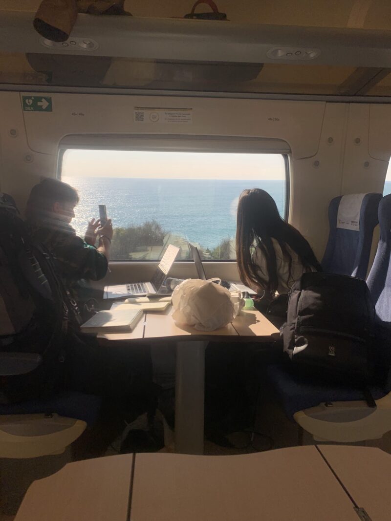 two people on an oceanside train