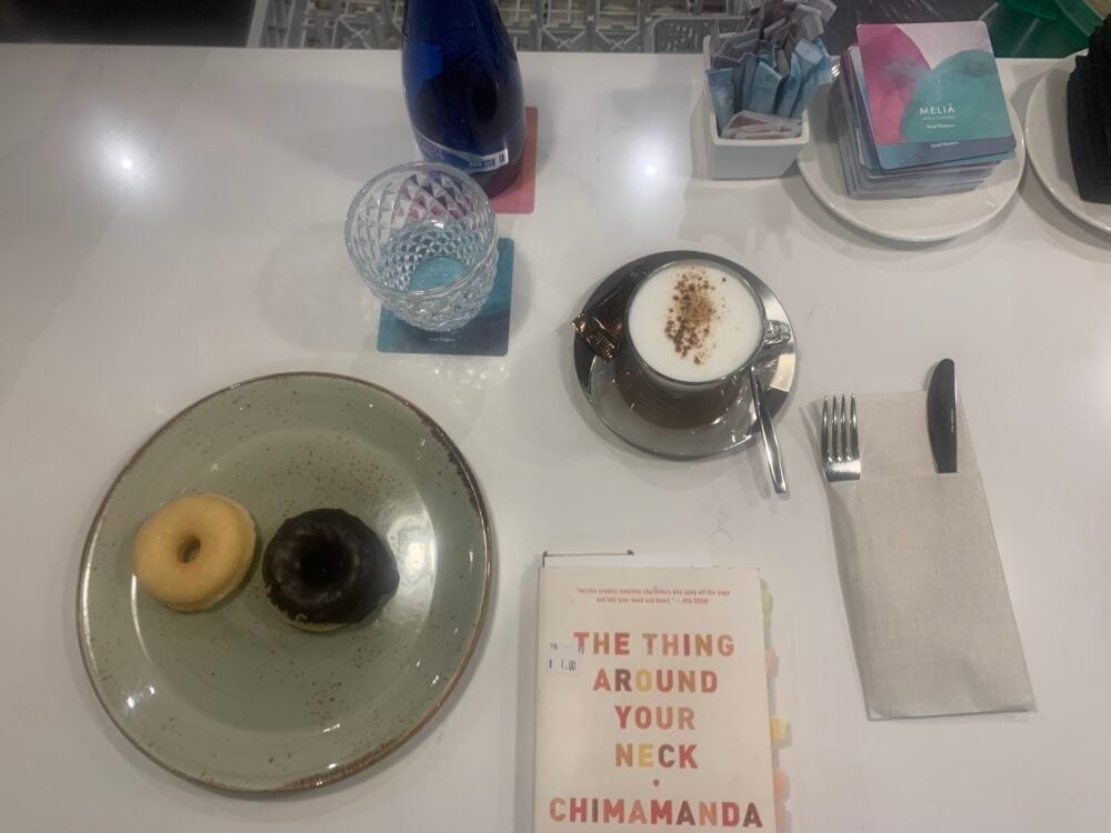 two donuts, coffee, and a book on a table