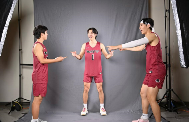 Three basketball teammates pointing at each other.