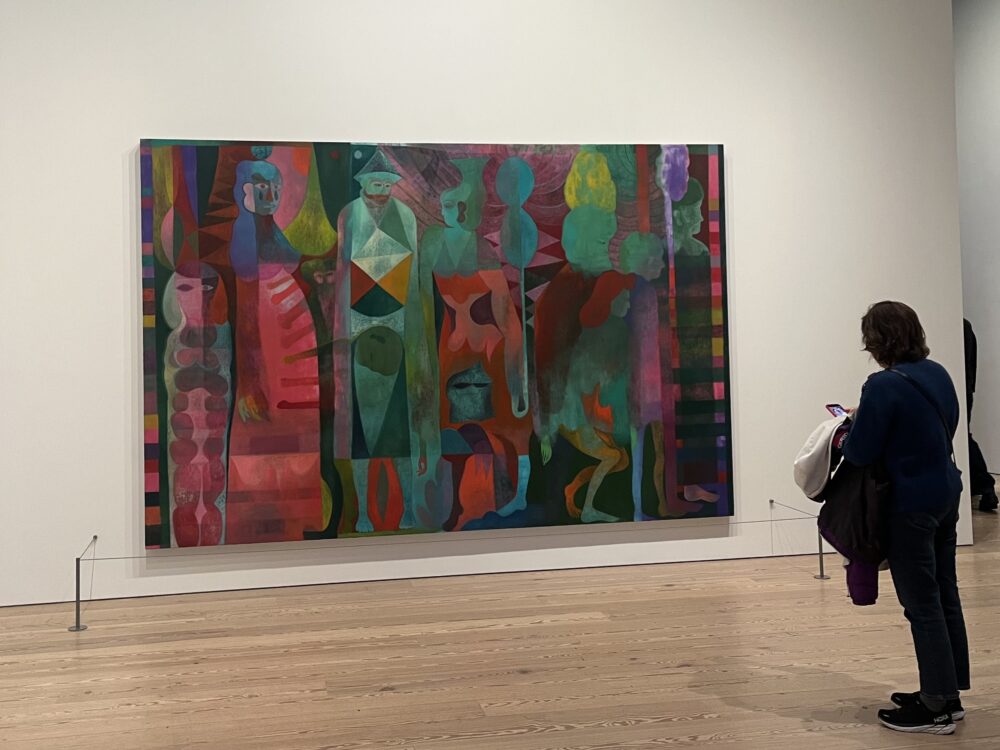 a picture of a large painting on the wall. it features several brightly colored, gestural figures, oriented in a horizontal, almost temporal format.