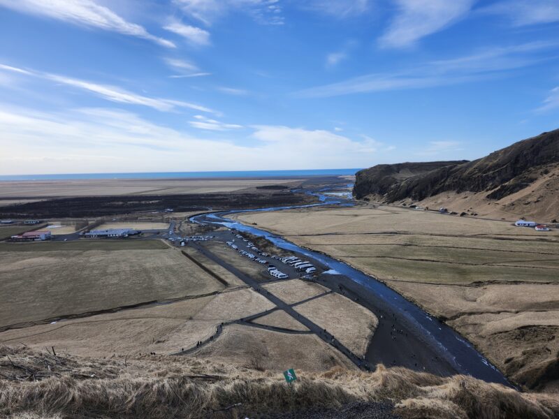 high-up view of brown plains and ocean