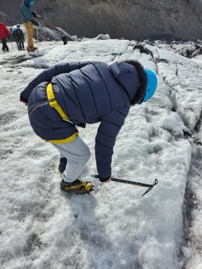 image of person using pickaxe to pick at ice
