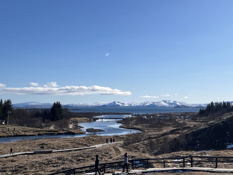 image of river with mountains in the distance + low clouds