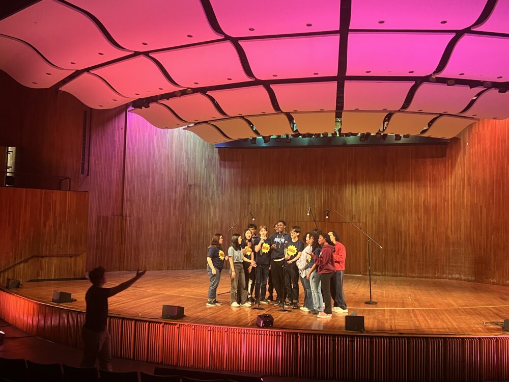 A group of students rehearse on stage at Kresge Auditorium.