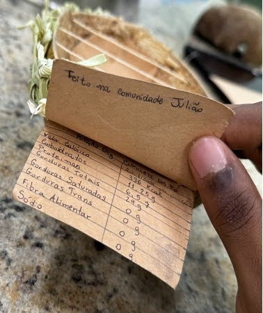 A nutrition label handwritten on paper in Portuguese. The heading says