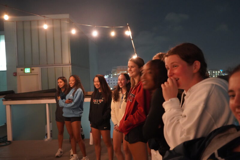 Team watching perfomance while smiling.