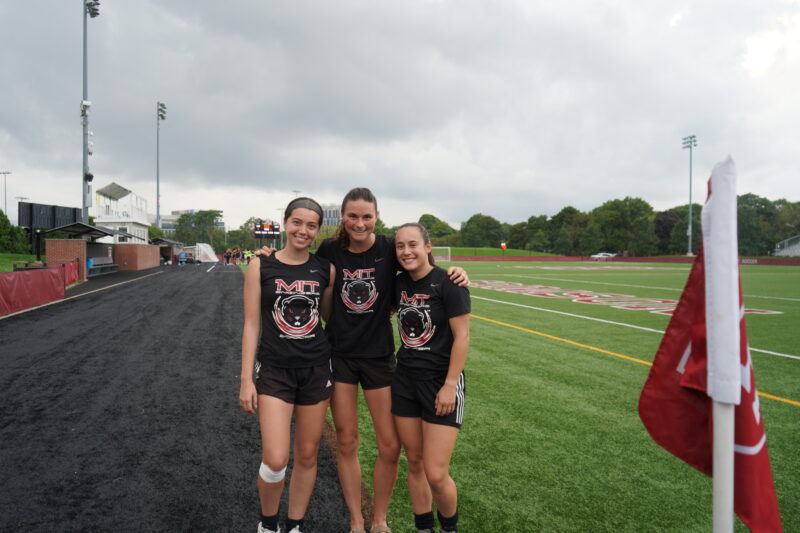 Three players posing on Harvard field.