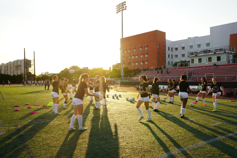 Soccer players juggling a ball.