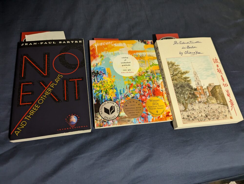 three books on a blue background; no exit and other plays (sartre), catalog of unabashed gratitude (ross gay), and a silent traveler in boston