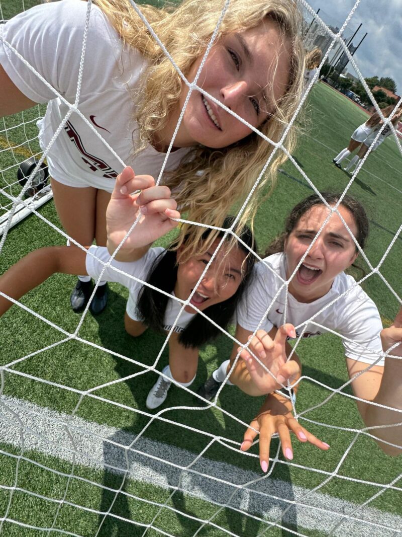 Players hanging onto soccer net.