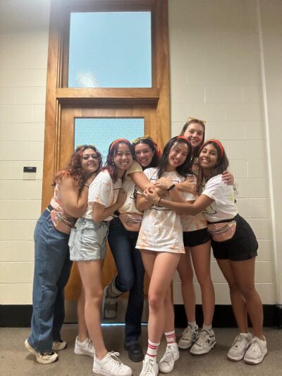 Group posing at sorority recruitment dressed in orange theme.