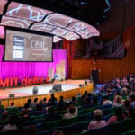 A student stands on the stage to pitch their startup to an audience at the 2024 delta v Demo Day.