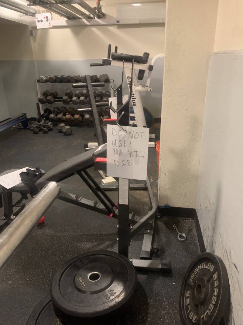 a picture of a machine in a gym with a sign taped on it that does DO NOT USE
